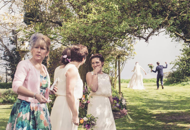 Bride and Groom Having Fun While Bridesmaids Laugh Cute and Funny Wedding Photo Idea by Him and Her Photography | Confetti.co.uk