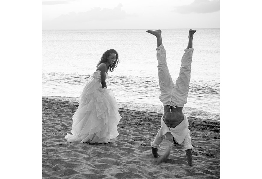 Bride and Groom Laughing on the Beach by Relate Studios - Groom Doing a Hand Stand on the Beach as the Bride Laughs - Beautiful Black and White Wedding Photography | Confetti.co.uk