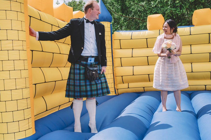 Bride and Groom on a Bouncy Castle Wedding Photo by Emma-Jane Photography | Confetti.co.uk