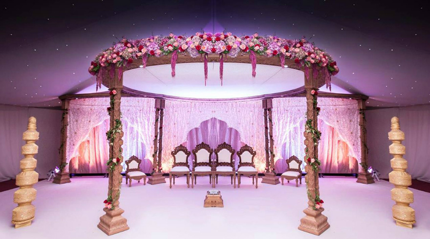 Extravagant Asian Wedding with Ornate Thrones with Flowers and Golden Pillars - Newland Manor Asian Wedding Specialist Wedding Venue - Elaborate Pelaminan Wedding Throne | Confetti.co.uk