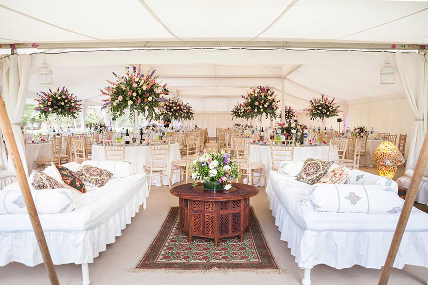 Lulu Pearl Tent from Arabian Tents - Moghul Marquee Party Tent and Luxury Wedding Marquee - Spring Themed Rustic Wedding Tent with Elaborate Floral Displays and Couches - Photo via lighttrick.co.uk | Confetti.co.uk