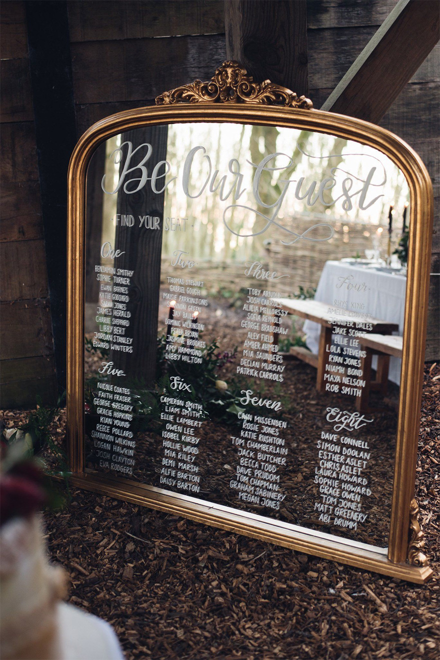 Be Our Guest Beauty and the Beast Style Antique Gold Mirror with Hand Written Calligraphy Table Plan by Sophie Carefull Photography - Mirror Wedding Sign | Confetti.co.uk