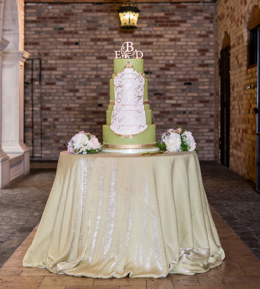 Green and White Tall Tiered Wedding Cake with Gold Script and Monogram Acrylic Cake Topper - Fairytale Wedding Cakes - Wedding Cake Table Ideas | Confetti.co.uk