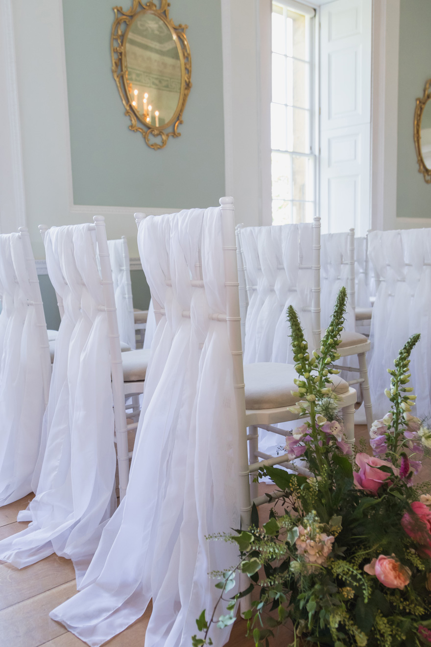 Pretty Wedding Chair Decor - White Wedding Chair Covers - Wedding Ceremony Seating Ideas - Fabric Woven Through Wedding Ceremony Seating | Confetti.co.uk